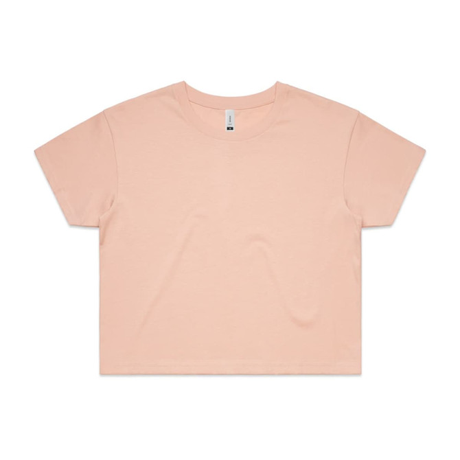 A cropped t-shirt in a soft peach colour, featuring a simple design and a small logo.