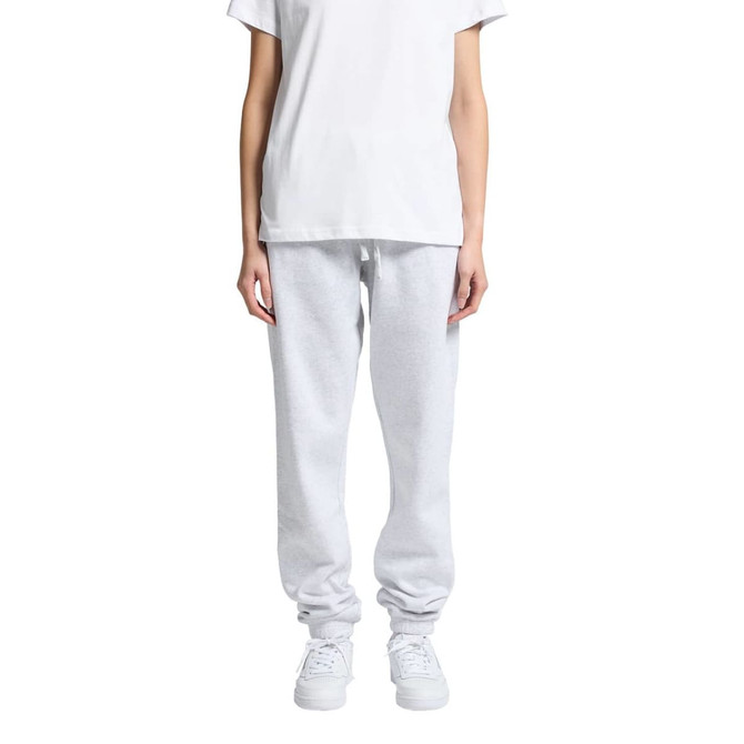 Grey track pants displayed on a model, paired with a plain white t-shirt and white sneakers. The pants have a logo.