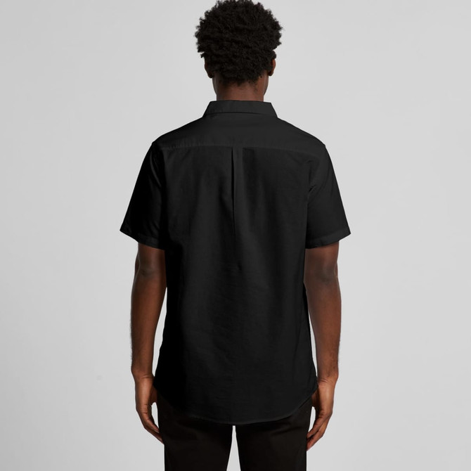 A black short-sleeved button-up shirt features a standard collar and a back pleat, with a logo present.