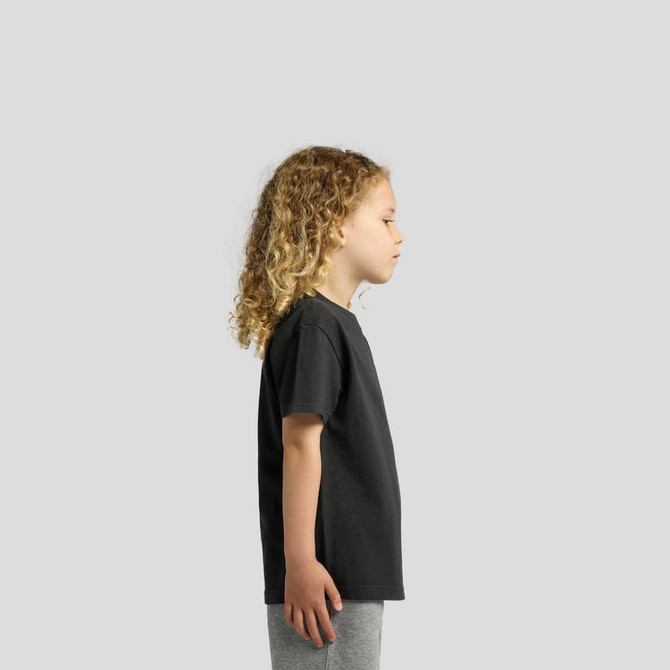 A black kids' T-shirt displayed on a child with curly hair, shown from the side. The child is wearing grey pants.