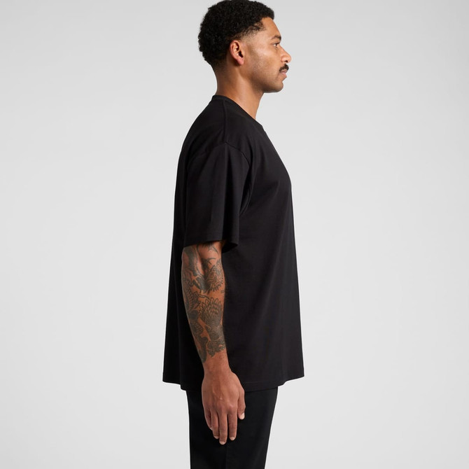 A black oversized t-shirt displayed on a male model, featuring a simple design and a logo.