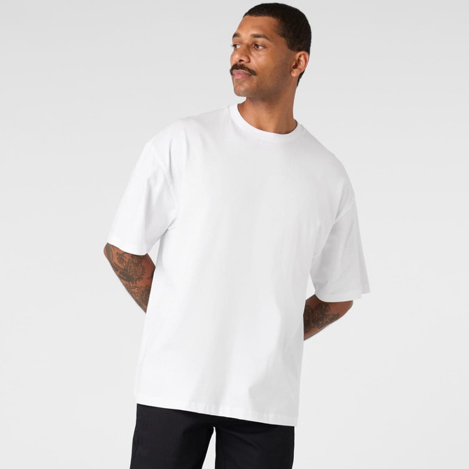 A white oversized t-shirt with short sleeves, featuring a logo. The model has a moustache and tattoos.