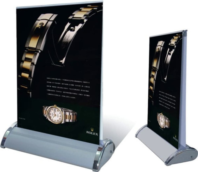 A double sided pull-up banner with a sleek silver base, featuring a black background and an image of a watch.