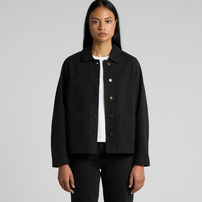 A black canvas chore jacket with a button front and pockets, worn by a model with long hair.
