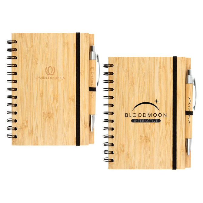 A bamboo notebook with a spiral binding and a black elastic band, accompanied by a pen, both featuring logos.