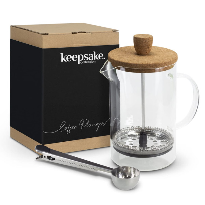 A glass coffee plunger with a cork lid, accompanied by a stainless steel measuring spoon, in a box with branding.