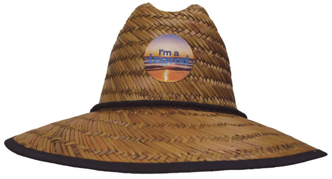 A straw hat in a burnt finish with a circular logo in the centre and a wide brim.