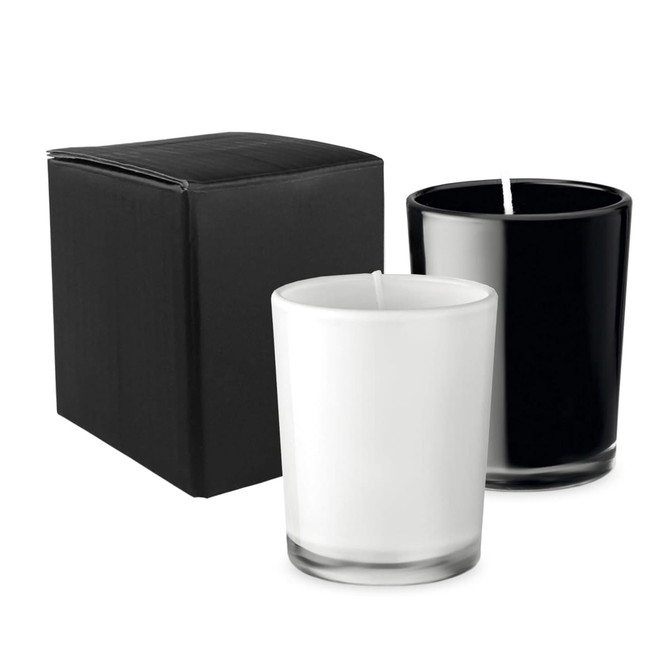 A set of two glass candles, one black and one white, with a black box packaging. Each candle has a wick.