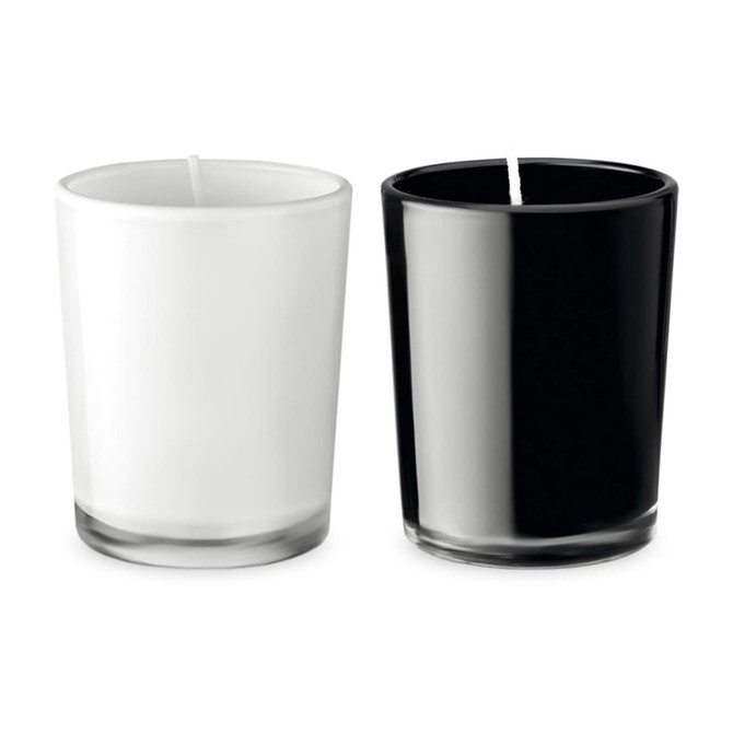 Two glass candles, one white and one black, each in clear holders with a wick visible.