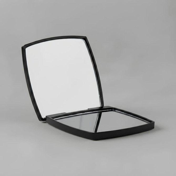 A compact mirror with a sleek black casing, featuring two mirrored surfaces inside.