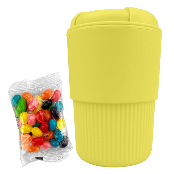 A drink bottle in bright yellow silicone, accompanied by a packet of assorted jelly beans.