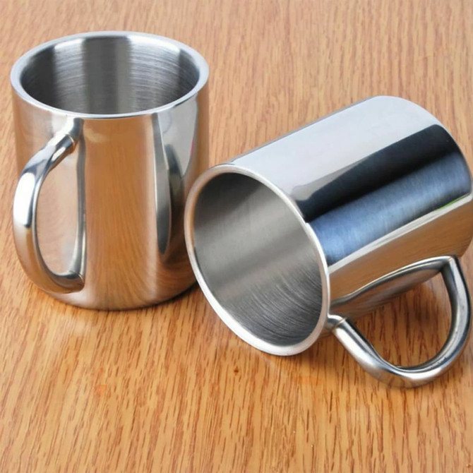 Two stainless steel coffee mugs are positioned on a wooden surface, featuring sleek designs and sturdy handles.
