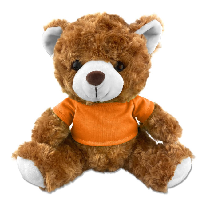 A brown teddy bear plush toy wearing an orange shirt, featuring a friendly face and soft fur. It has a logo on it.