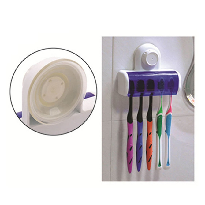 A toothbrush holder with a suction cup, featuring four toothbrush slots in various colours: purple, green, blue, and orange.