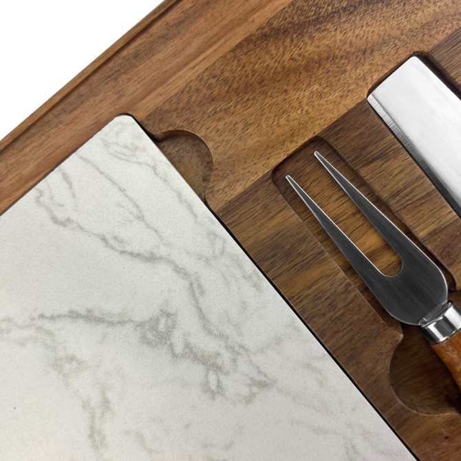 A marble cheeseboard with a wooden base and stainless steel knife and fork set.