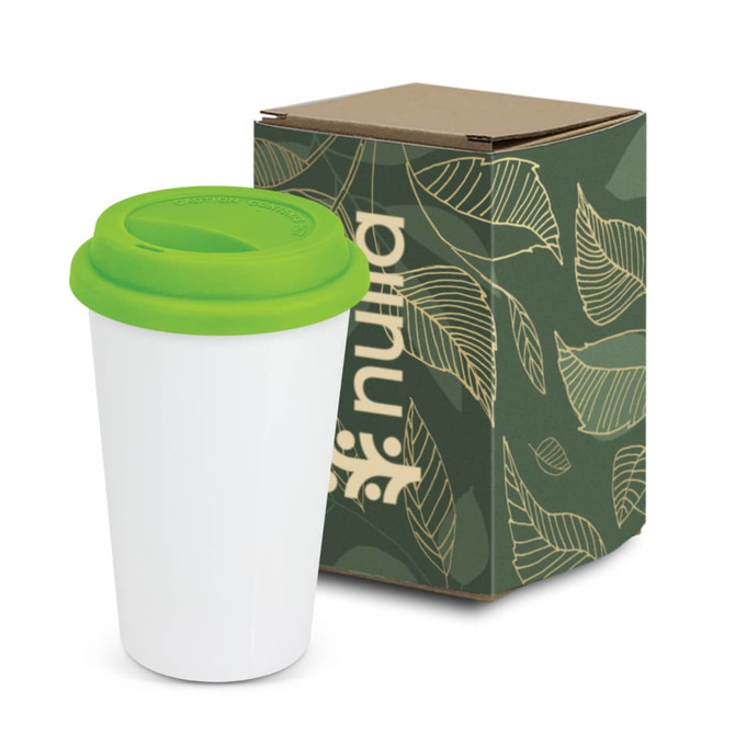 A coffee cup with a white body and green lid, accompanied by a patterned cardboard box featuring leaf designs.