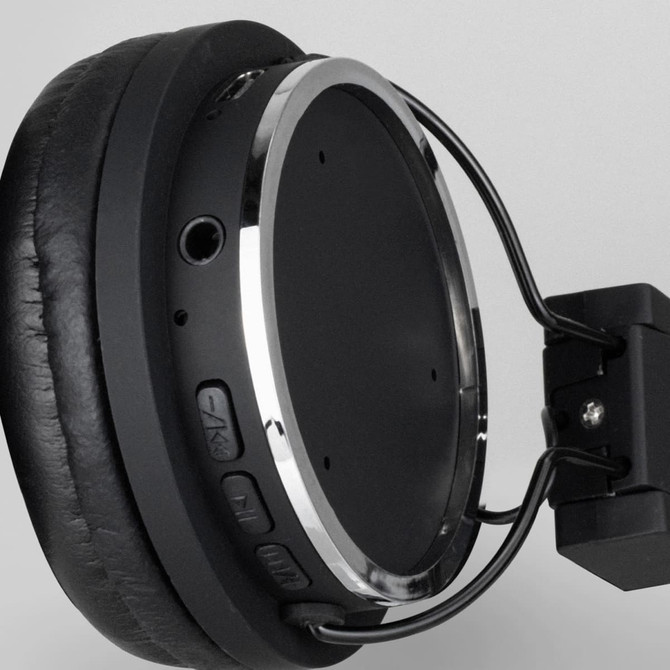 A pair of black Bluetooth headphones with silver accents and control buttons on one side.