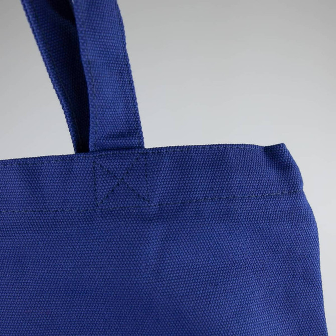 A blue 450gsm Hawaiian canvas tote bag featuring sturdy handles and a textured surface, with a branding logo.