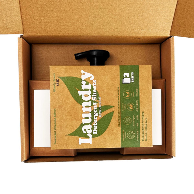 A brown box containing laundry detergent sheets and a black spout, with eco-friendly branding visible.