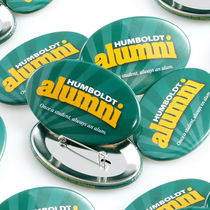 A collection of oval button badges in green with a logo and a pin backing.