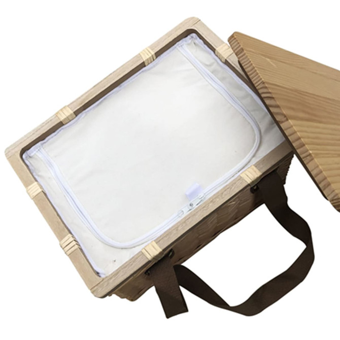 A square wicker picnic cooler basket in natural wood tones with a cream interior and a wooden lid. Features a brown handle and logo.