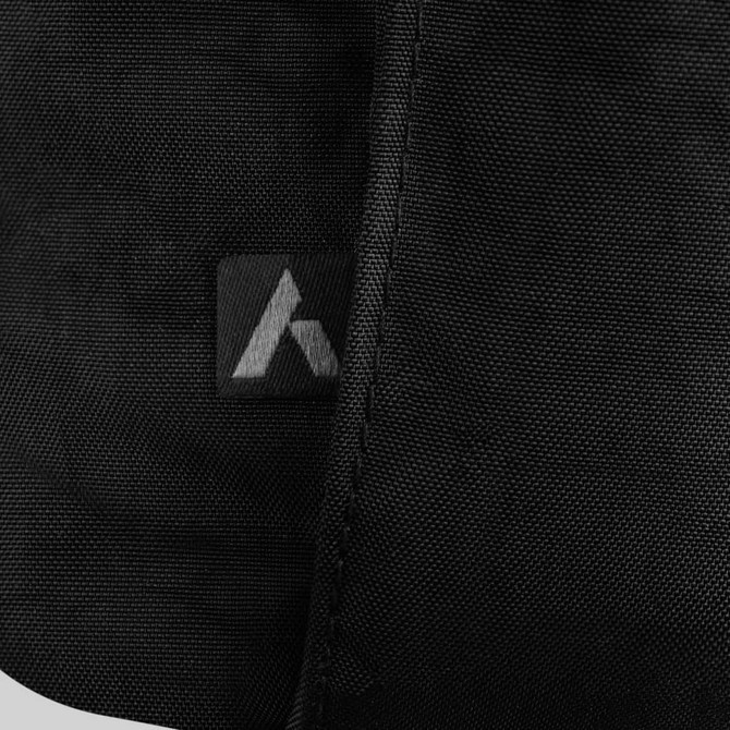 A close-up of a black fabric texture with a small logo on the side, featuring a sleek design.
