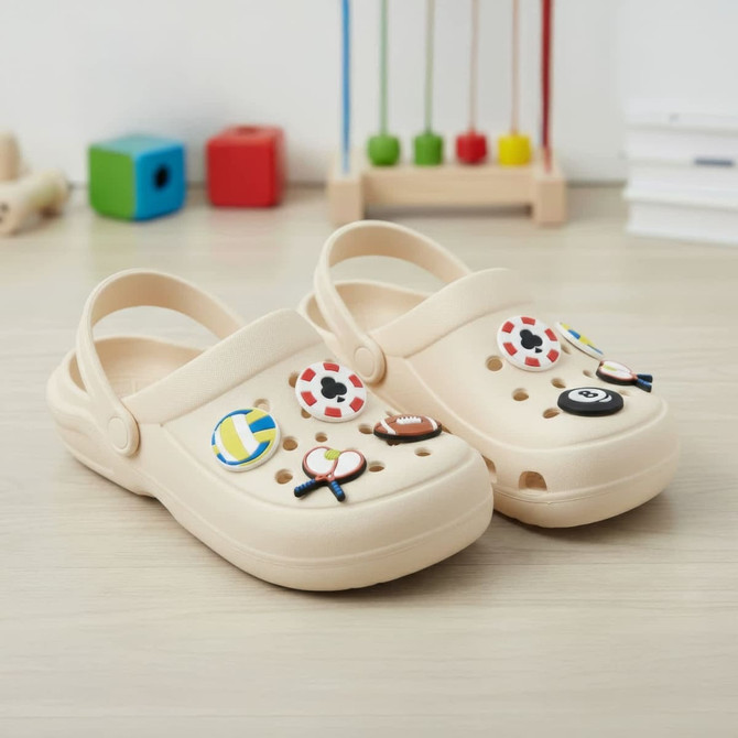 A pair of beige clogs adorned with various colourful shoe charms, including sports and cartoon designs.