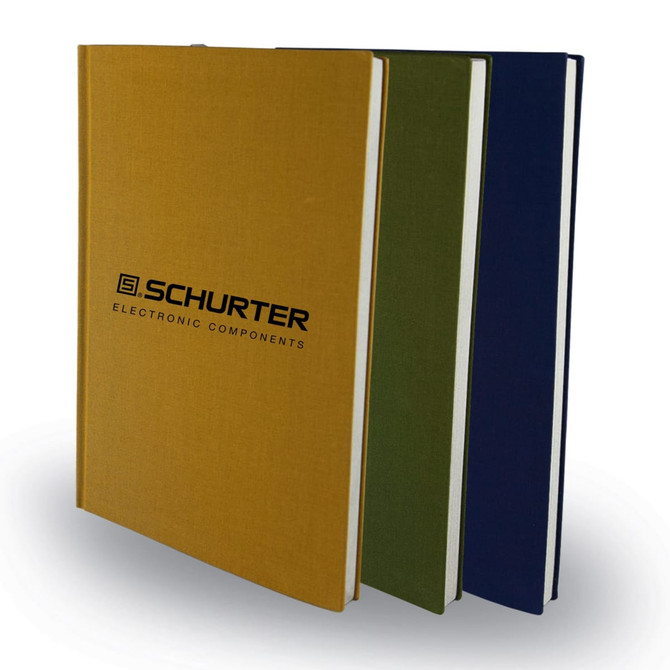 Three notebooks in gold, green, and navy blue, featuring a logo on the cover.