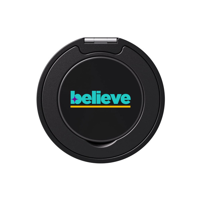 A round black phone grip and stand featuring the word "believe" in turquoise and yellow.