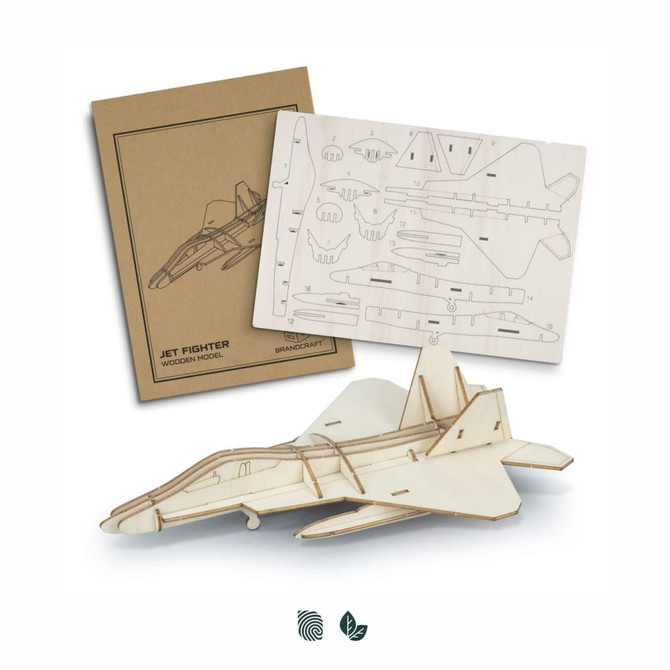 A wooden model of a jet fighter in natural wood tones, packaged with a template and parts for assembly.