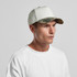 A two-tone camo cap featuring a light-coloured crown and a camouflage-patterned peak, displayed on a model.