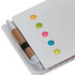 A white sticky note pad featuring colourful dots in orange, green, pink, and blue, with a pen attached.