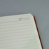 An A5 notebook with lined pages and a brown cover, featuring a header for memo number and date.
