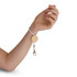 A hand wearing a white elastic keytag with a wooden circular pendant and a metal clip.