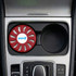 A round, red air freshener fitting into a car compartment, featuring a logo on its surface.