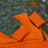 A hoodie featuring a camouflage pattern in greens and browns, with orange cuffs and hem. It has a logo.