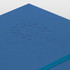 A blue notebook featuring a debossed design and a ribbon marker. It includes a logo on the cover.