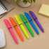 A collection of six highlighter pens in pink, orange, yellow, green, blue, and purple, arranged on a desk.