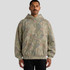 A faded camo hoodie in earthy tones, featuring a hood and a front pocket. The model stands against a neutral background.