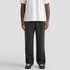 Relax Faded cuffless track pants in black, styled with a white T-shirt and navy shoes, featuring a logo.