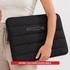 A black neoprene laptop sleeve with a padded design and a logo, held in a person's hands. More colours available.