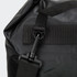 A black dry bag with a sturdy strap and clip attachment, featuring a textured surface. It has a branding logo visible.