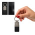 A hand holds a silver keytag with a black leather base, packaged in a sleek black box.