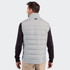 A man wearing a light grey Cutter & Buck Evoke hybrid vest, viewed from the back. The vest features a high collar and a logo.