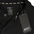 A black polo shirt featuring a collar, care label, and tag, with a logo present on the collar.