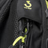 A close-up of a black backpack feature with a green zipper and an anti-thief clip. It has a textured fabric.
