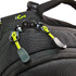 A close-up of black fabric with yellow accents, featuring clips and adjustable straps on a backpack.