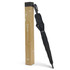A black umbrella with a curved handle displayed next to a tall, branded cardboard box.