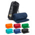 A rolled navy fleece blanket and a black carry bag, surrounded by fleece blankets in various colours.
