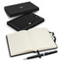 A black notebook with lined pages and a silver pen, presented in a sleek black gift box. The set features a logo.